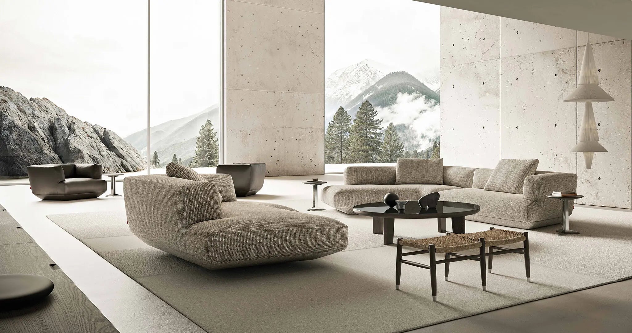Modern living room with a large sectional sofa and coffee table, featuring a mountain view. Designed by Flexform.